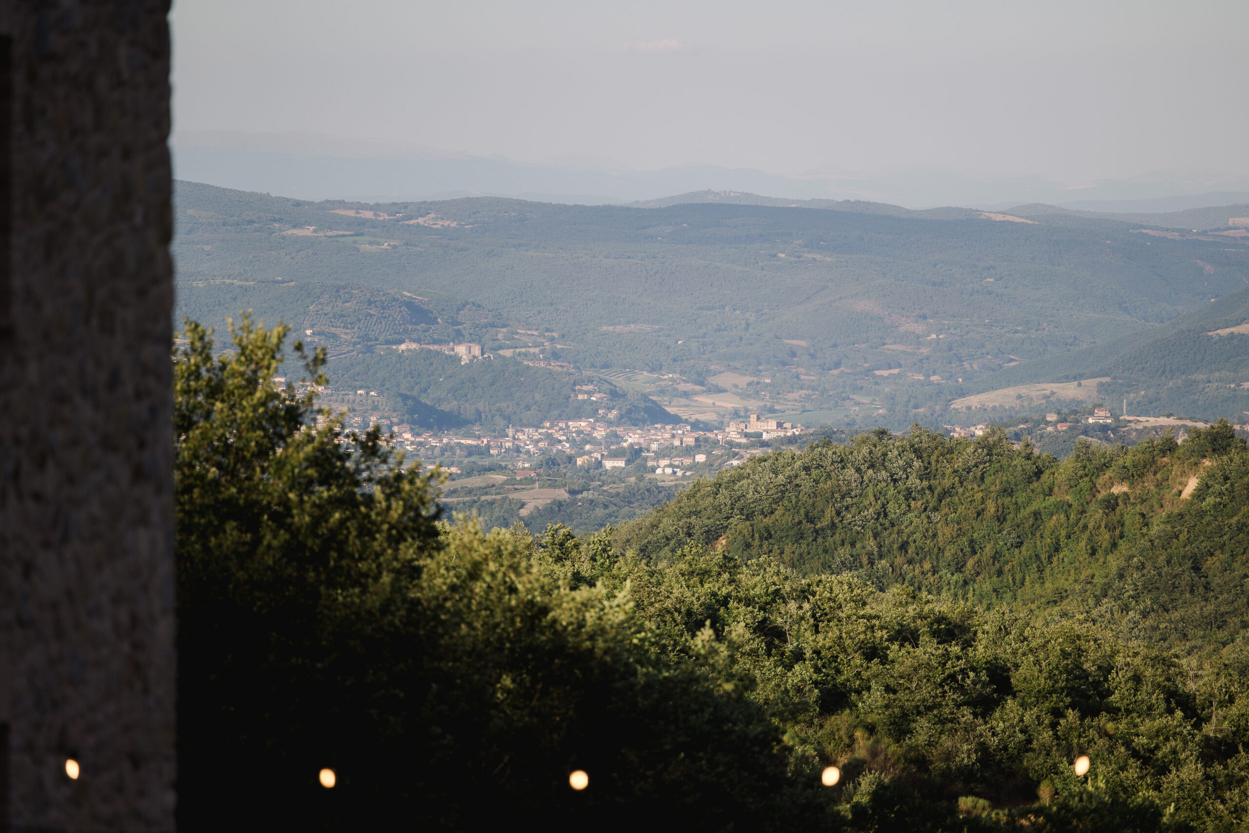 Hazy view from the hamlet over wooded hills to a distant Umbrian hill town in the valley